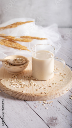 Oat flakes and milk on a glass bowl and jug of milk