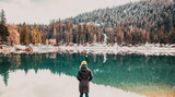 woman watchin amazing turquoise water of Caumasee in winter Switzerland slow travel