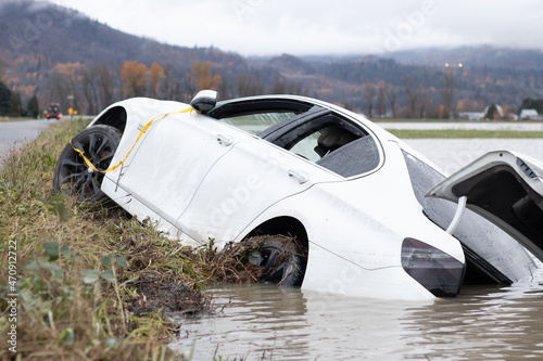Abandoned car slid off road in Abbotsford flooding and storm, British Columbia, Canada photo