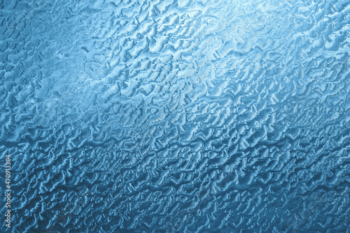 Abstract background. Embossed self-adhesive film on the window, tinted blue.