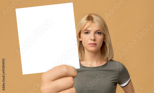 Portrait of blonde woman with calm facial expression showing card