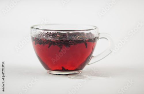 Karkade. Tea drink in a glass. Red liquid in a glass. Dried petals. Hibiscus. Sudanese rose