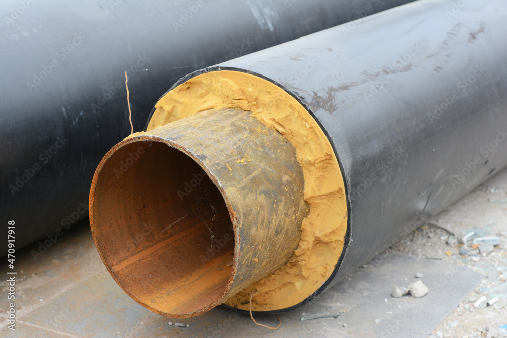 A close-up of pre-insulated multilayer metal steel pipe for hot water and heating. Prefabricated direct buried insulation pipe for hot water supply. A close-up of pre-insulated multilayer metal steel pipe for hot water and heating. Prefabricated direct buried insulation pipe for hot water supply.