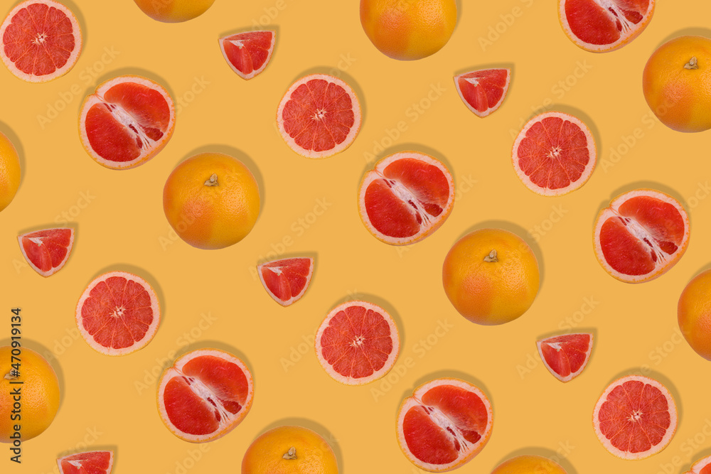 Creative pattern with fresh whole and sliced grapefruit on yellow background. Minimal fruit concept. Creative pattern with fresh whole and sliced grapefruit on yellow background. Minimal fruit concept.