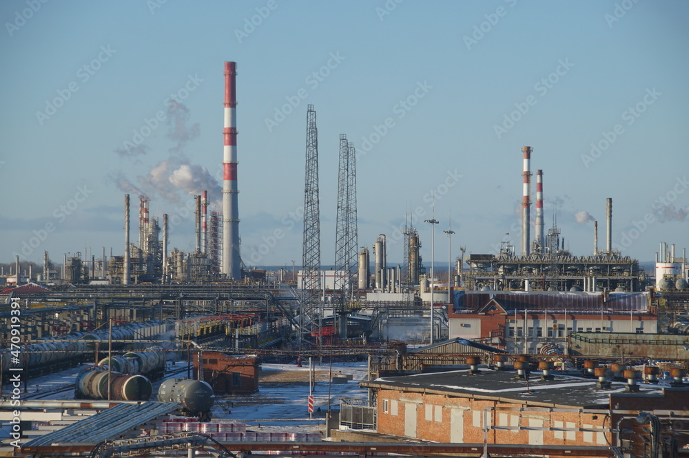 An oil and gas processing plant. Factory buildings, production pipes, railway tanks. Panorama of a large factory. An oil and gas processing plant. Factory buildings, production pipes, railway tanks. Panorama of a large factory.