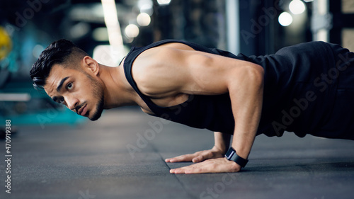 Sporty Young Arab Man Making Floor Push Up Exercise In Gym