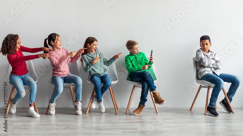 Kids Laughing At Victimized African Boy Bullying Using Smartphone Indoor