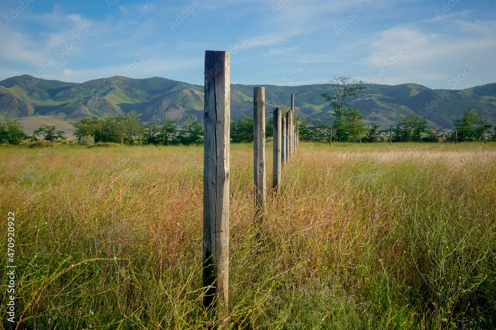 Wooden pillars in a field against the background of mountains in Dagestan