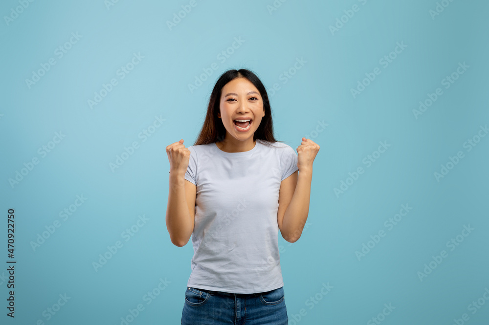 Big luck. Overjoyed asian lady raising fists and exclaiming with excitement, emotionally celebrating success Big luck. Overjoyed asian lady raising fists and exclaiming with excitement, emotionally celebrating success