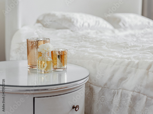 candle and aroma diffuser on the bedside table in gold clouse up