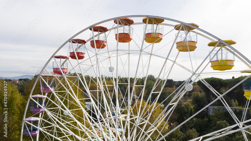 Aerial view of a ferris wheel inside Rome amusement park, located in the Eur district. There is no one on the rides. Aerial view of a ferris wheel inside Rome amusement park, located in the Eur district. There is no one on the rides.
