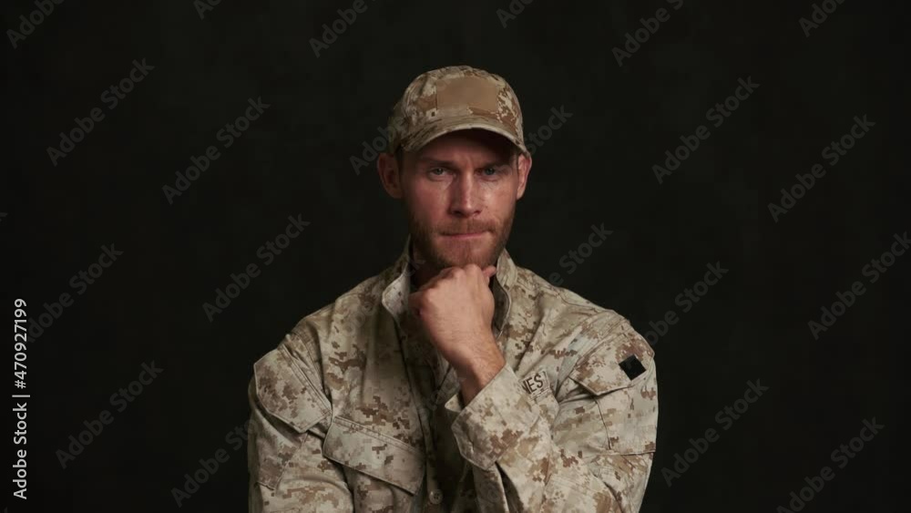 Pensive military man agree with something in black studio Pensive military man agree with something in black studio