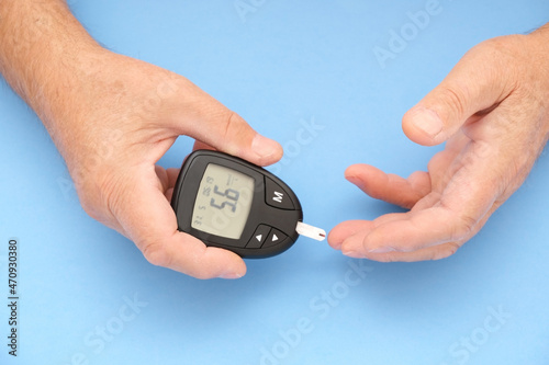 Old man measures blood sugar