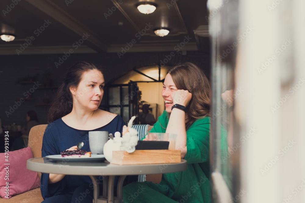 two women talking and drinking coffee in cafe two women talking and drinking coffee in cafe