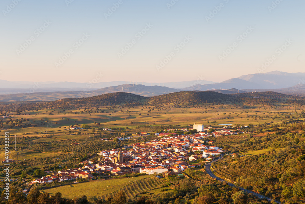 Panoramic of town surrounded by nature with wind energy mills in the background