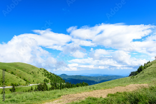 Scenic view over Bucegi Mountains (Muntii Bucegi) in Romania in a sunny summer day with clear blue sky and white clouds. photo