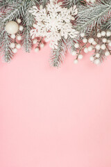 Christmas decorations at pink background. Fir tree and white christmas decorations. Flat lay image with copy space.