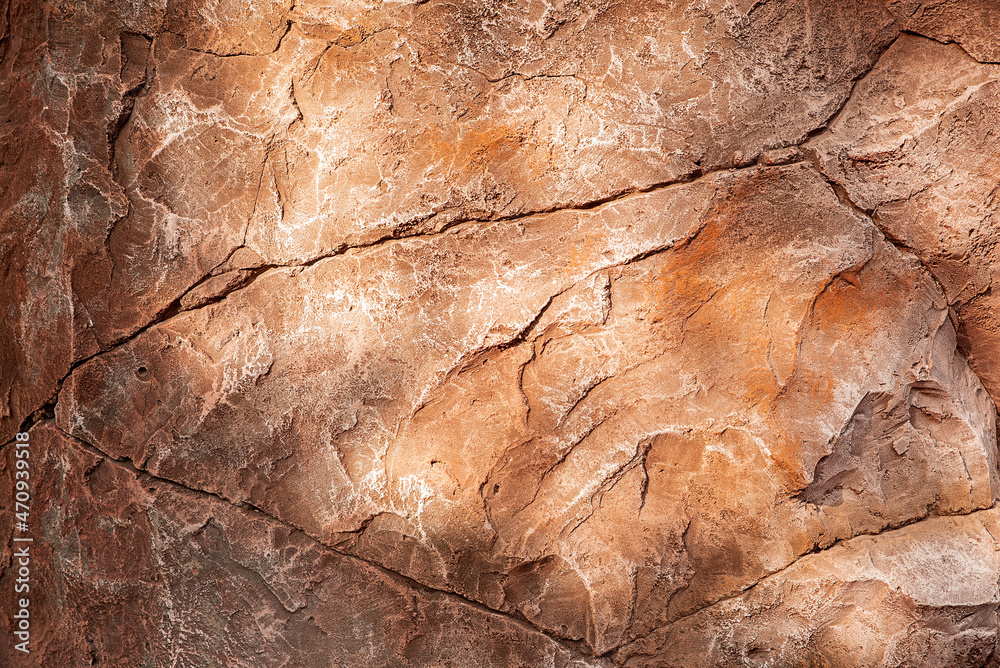 Textured brown rock background. Glare from the sun.