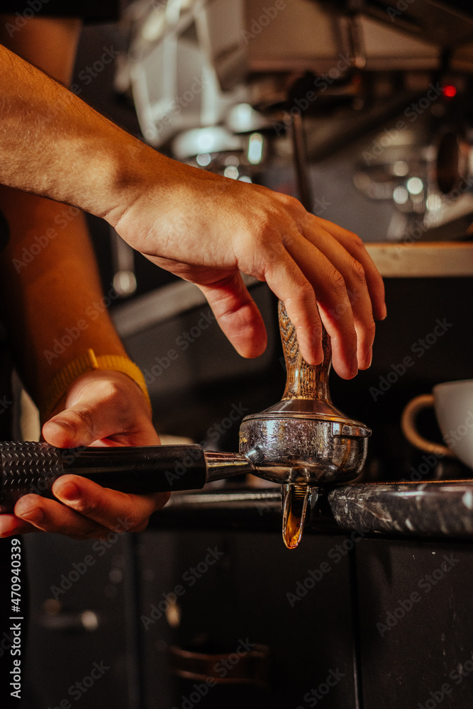 hands of a person in a restaurant making coffee