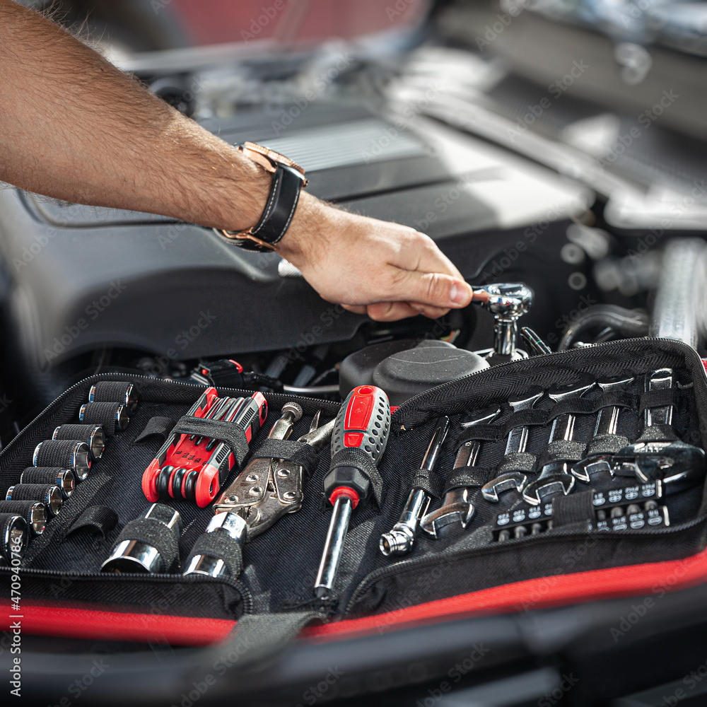 Mechanic examining and maintenance the engine a vehicle car hood Mechanic examining and maintenance the engine a vehicle car hood