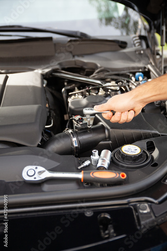 Mechanic examining and maintenance the engine a vehicle car hood