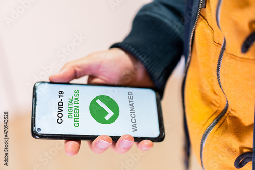 Covid-19 green pass, detail of a hand with a mobile phone with the health passport. Vaccination certificate, coronavirus photo