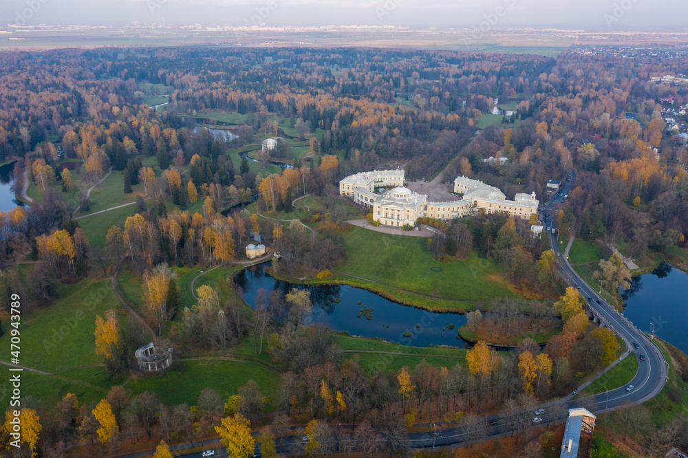 Naklejka premium Panoramic aerial view of the Pavlovsk Park and the Pavlovsk Palace on an autumn evening.Bright autumn landscape, Slavyanka river. A suburb of St. Petersburg.