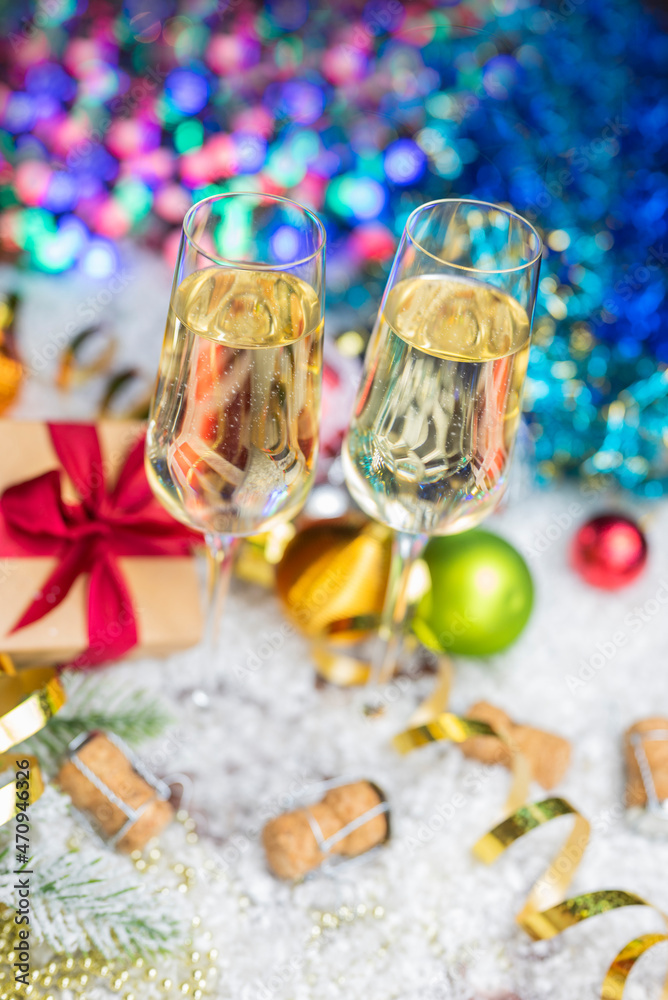 glasses with a drink champagne wine with a decor of Christmas toys on a bokeh background for the new year