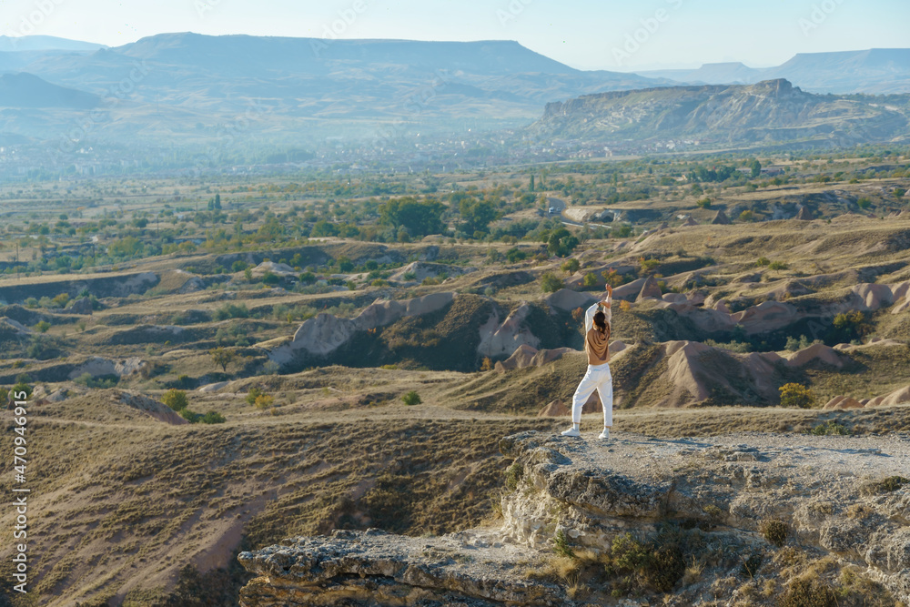 Naklejka premium Traveler woman standing on the edge of sandstone cliffs