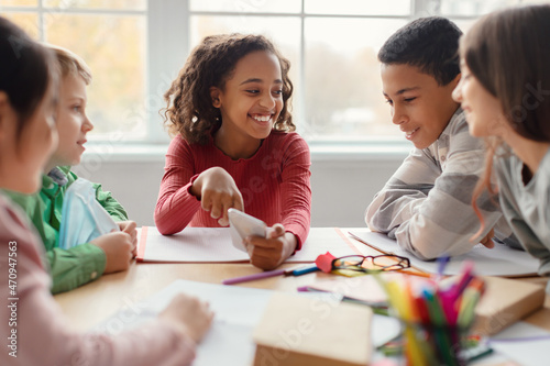 Fotografija School Children Having Fun Using Smartphone During Break In Classroom