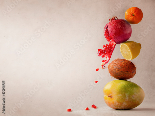 a tower of tropical fruits, balancing objects on a light background