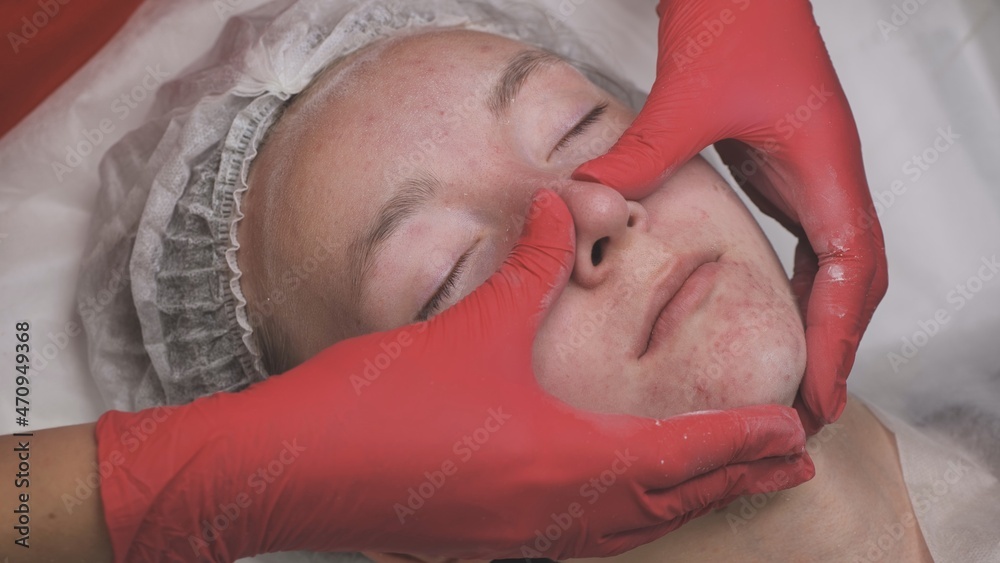 Naklejka premium Applying powder to the client's face and massage the client's problem skin.