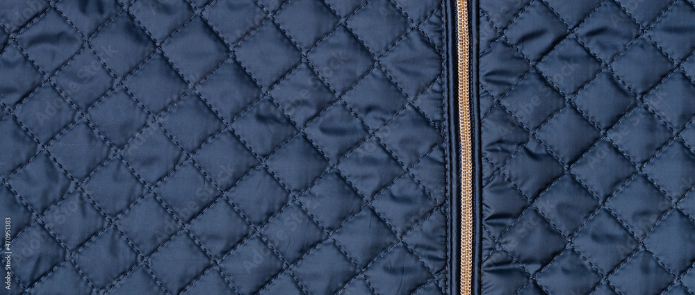 Blue texture of puffer, padded, down jacket. Background of urban winter outfit. Quilted pattern banner