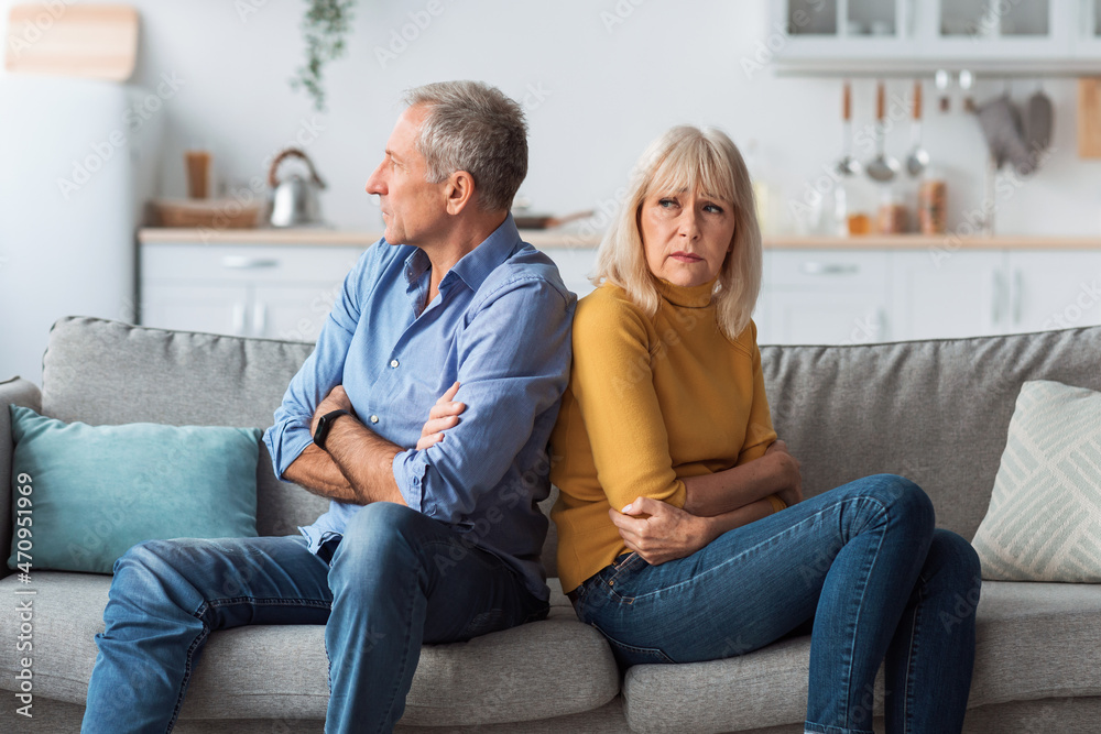 Offended Senior Couple Sitting Back-To-Back Having Marital Crisis At Home