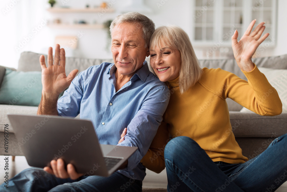 Senior Couple Making Video Call Waving Hand To Laptop Indoors Senior Couple Making Video Call Waving Hand To Laptop Indoors