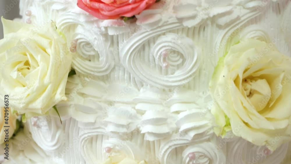 Big white wedding cake with red roses. Figures of brides on the cake Big white wedding cake with red roses. Figures of brides on the cake
