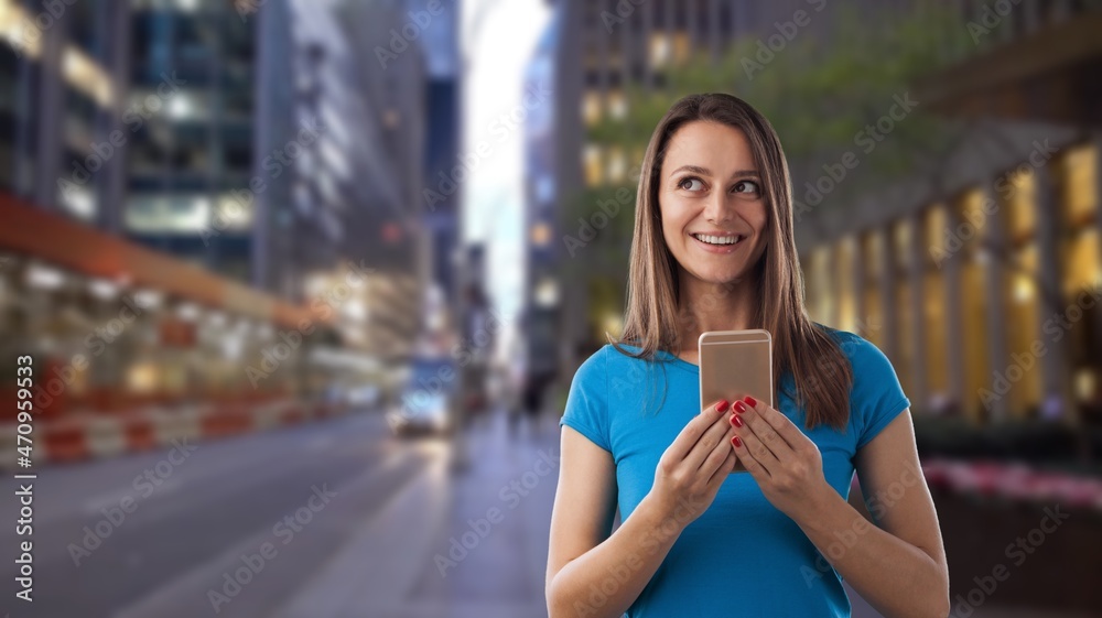 Young beautiful woman using mobile phone in the city background