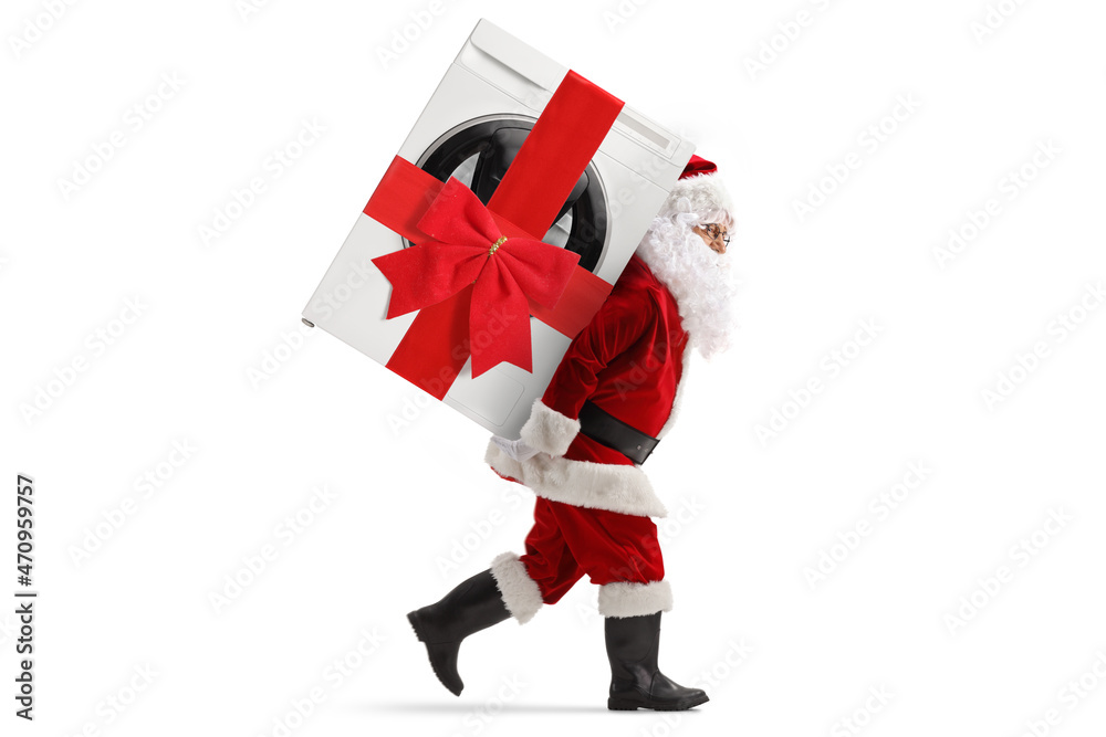 Full length profile shot of santa claus carrying a wrapped washing machine with a ribbon on his back Full length profile shot of santa claus carrying a wrapped washing machine with a ribbon on his back