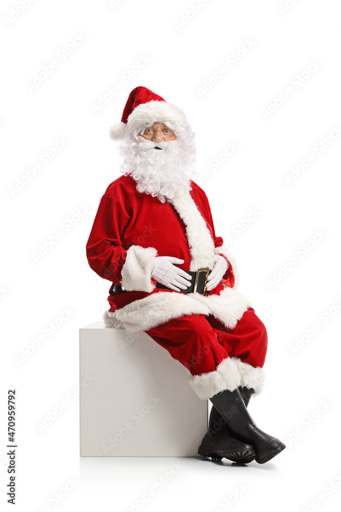 Santa claus sitting on a white cube and looking at camera Santa claus sitting on a white cube and looking at camera