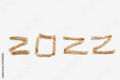 Happy New year 2022. New Year Concept welcoming New Year 2022 written by craft rope or jute on white background. Close-up. Two thousand twenty two. Eco holiday