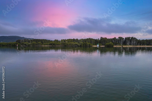 Soft and peaceful sunrise aerial waterscape with clouds and reflections