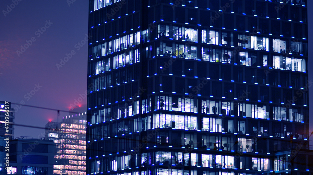 Corporate building at night - business concept. Glass wall office building .Modern office windows of skyscraper glowing at night. Corporate building at night - business concept. Glass wall office building .Modern office windows of skyscraper glowing at night.