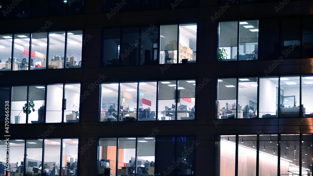 Corporate building at night - business concept. Glass wall office building .Modern office windows of skyscraper glowing at night. Corporate building at night - business concept. Glass wall office building .Modern office windows of skyscraper glowing at night.