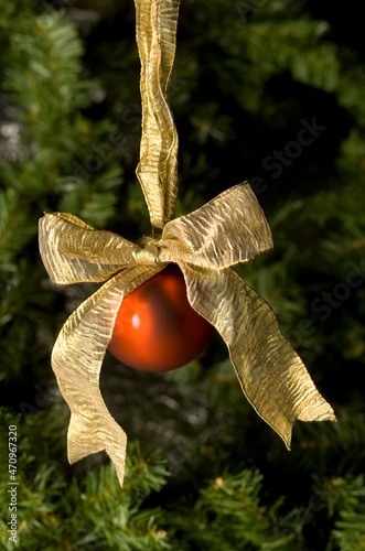 Red christmas ornament with gold bow and christmas tree