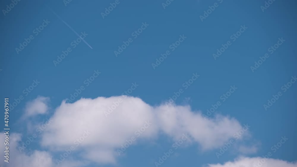 Distant passenger jet plane flying on high altitude on blue sky with white clouds leaving smoke trace of contrail behind. Air traveling concept Distant passenger jet plane flying on high altitude on blue sky with white clouds leaving smoke trace of contrail behind. Air traveling concept