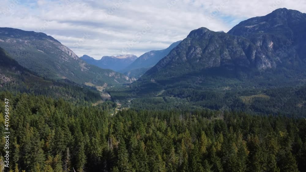 Top view of the surroundings of mountains with spruce forest and cloudy sky Top view of the surroundings of mountains with spruce forest and cloudy sky