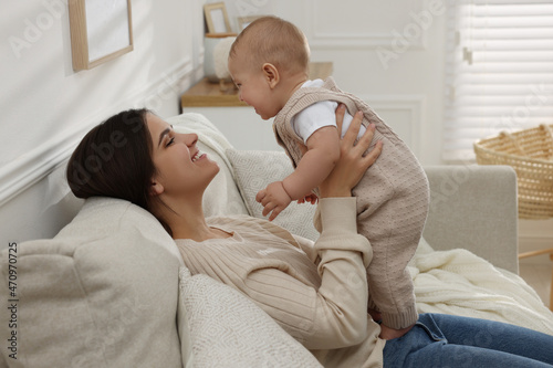 Happy young mother with her baby on sofa in living room