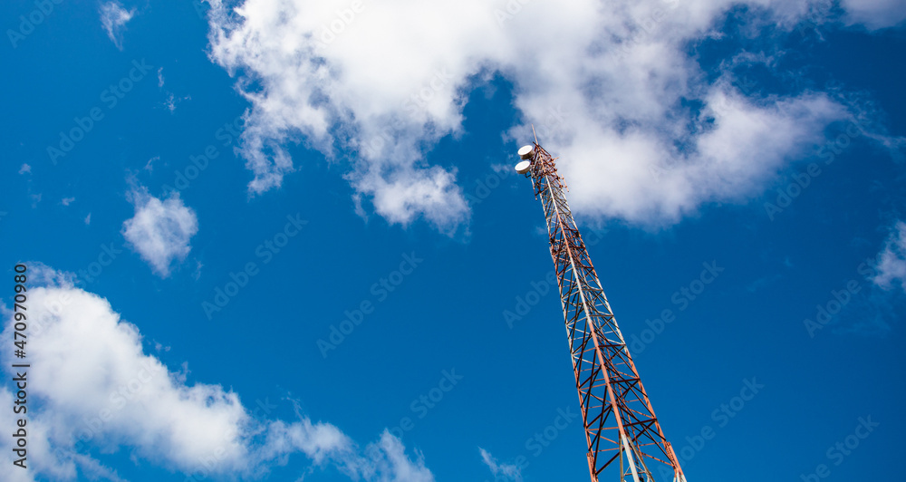Tower with cell phone antennas and blue sky with clouds. Tower with cell phone antennas and blue sky with clouds.