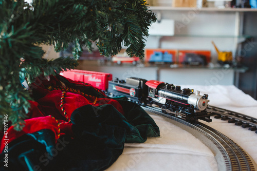 A model train and track ride around a Christmas tree in a shop