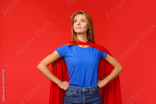 Canvastavla Confident woman wearing superhero cape on red background